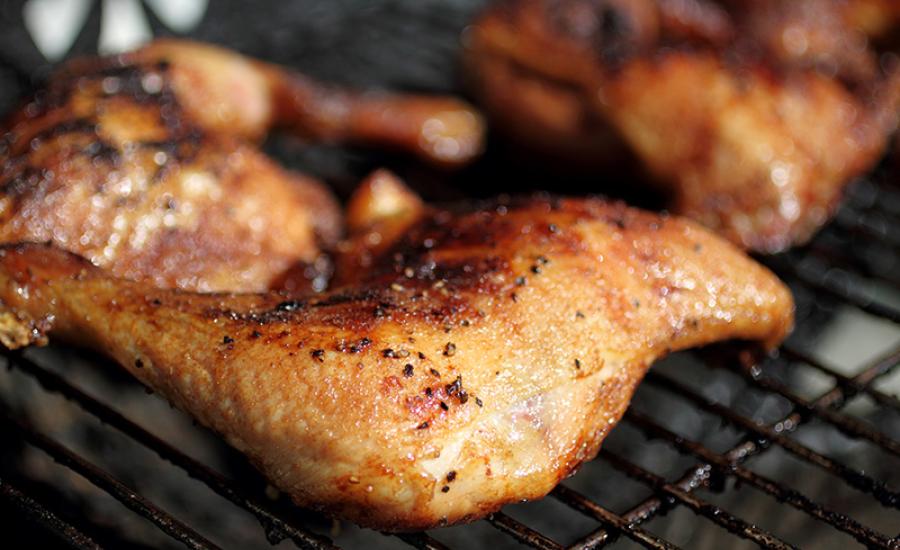 Photo of grilled quarter chicken thighs and legs on the BBQ.