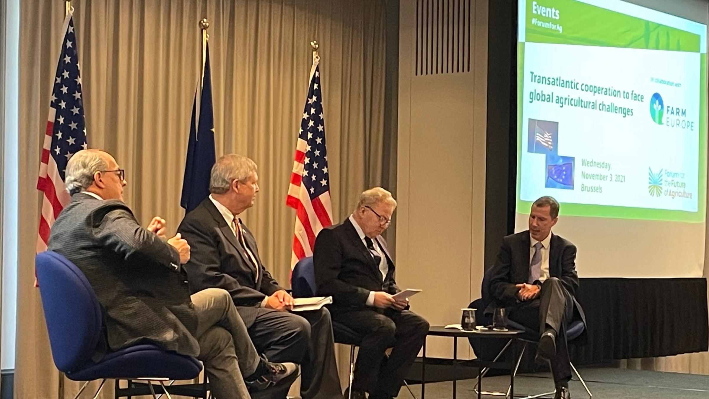 Secretary Vilsack and EU officials seated on state at event in Brussels