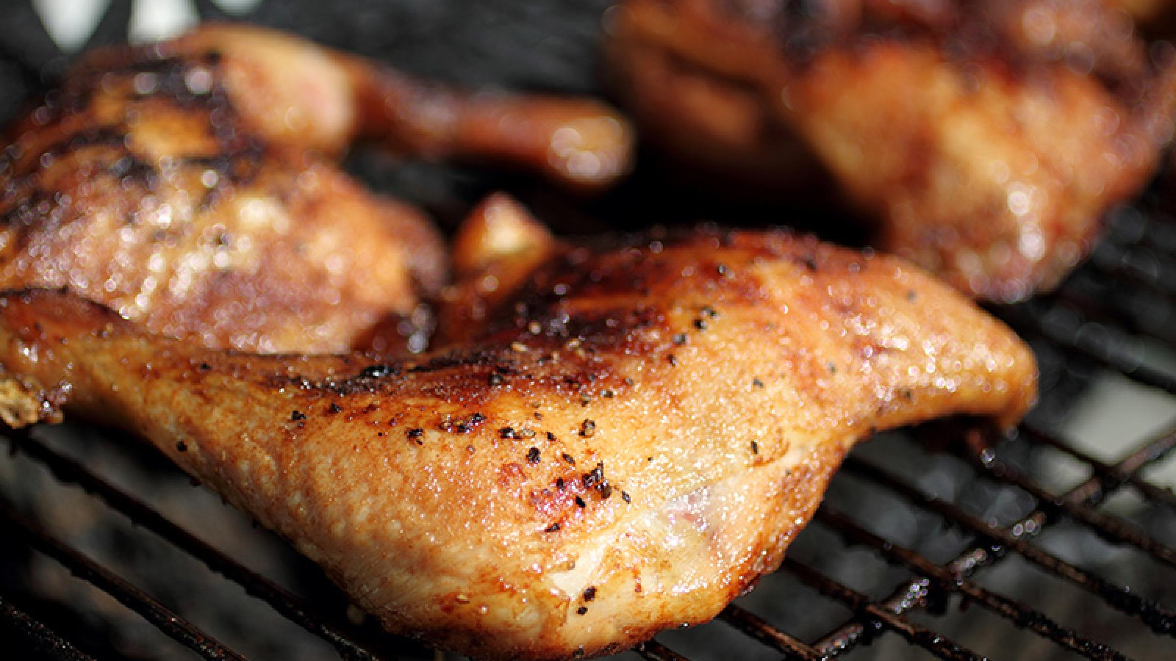 Photo of grilled quarter chicken thighs and legs on the BBQ.