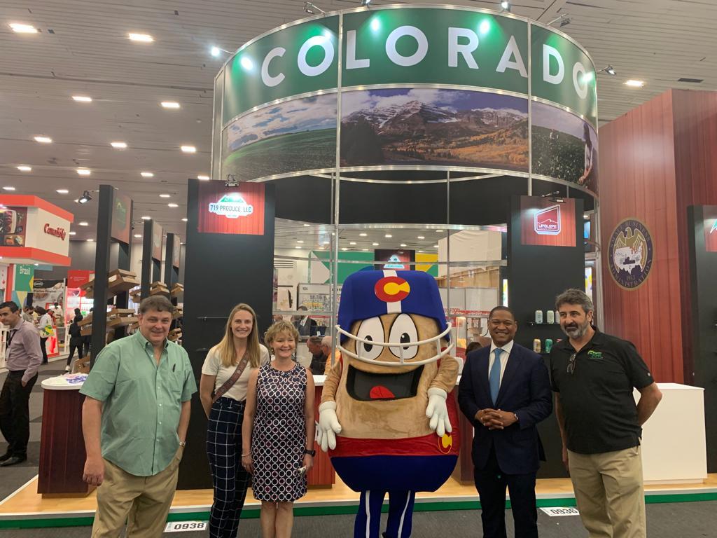 Group of people standing in front of Colorado trade show booth