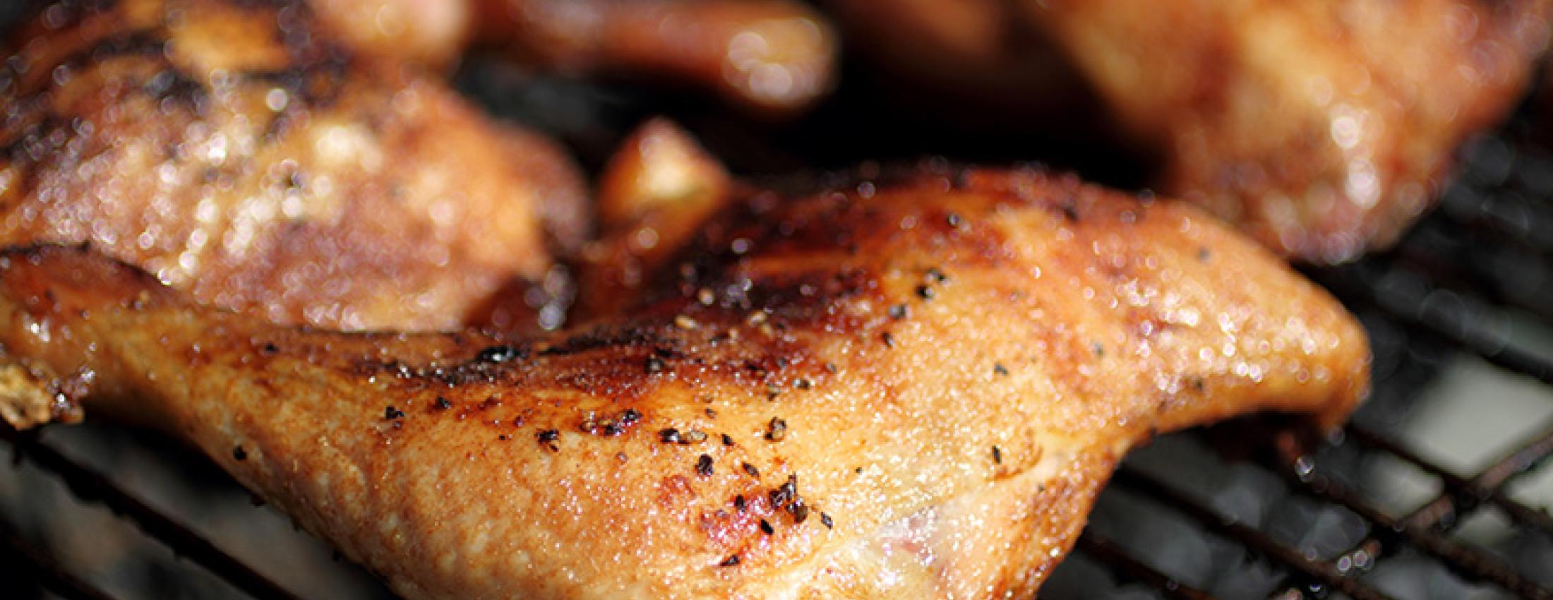 Photo of grilled quarter chicken thighs and legs on the BBQ.